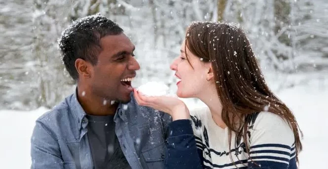 Paar von verschiedener Hautfarbe verliebt im Schnee