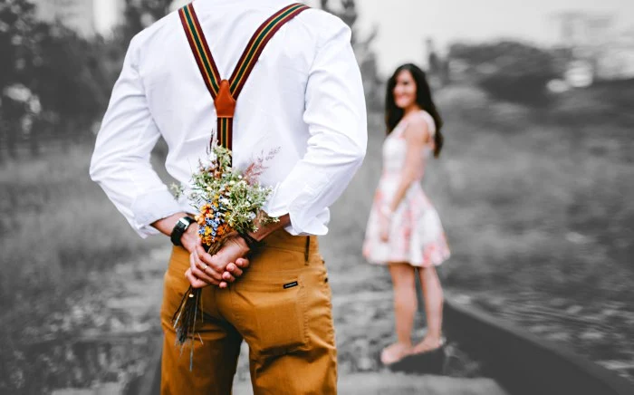 MarriageWeek, Lovers with man hiding a bouquet of flowers behind his back